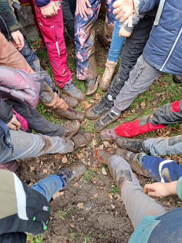 glücklich mit verdreckten Schuhen nach der Aktion